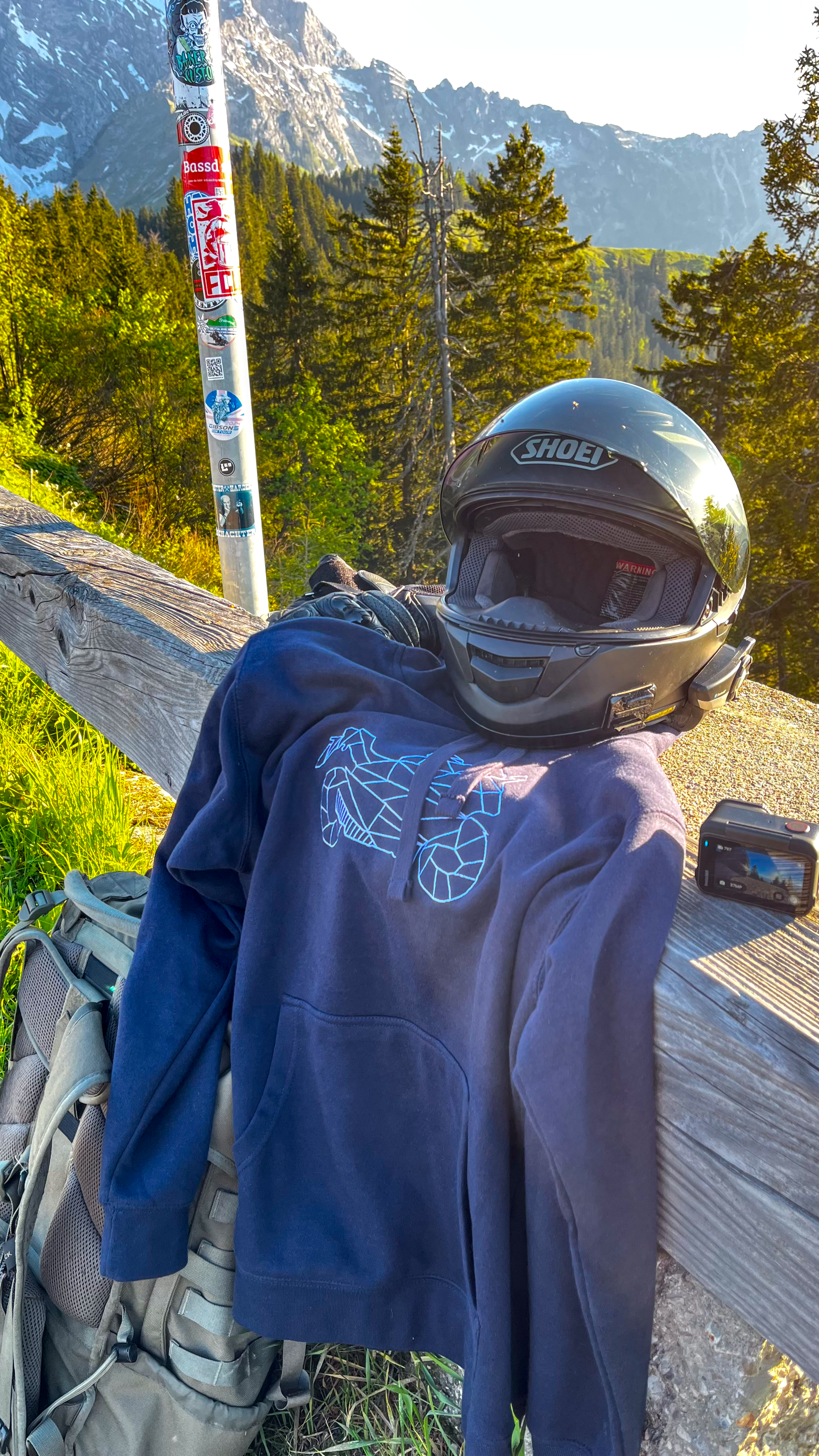 The Biker Mule motorcycle hoodie unisex in navy blue with helmet and outdoor mountain background