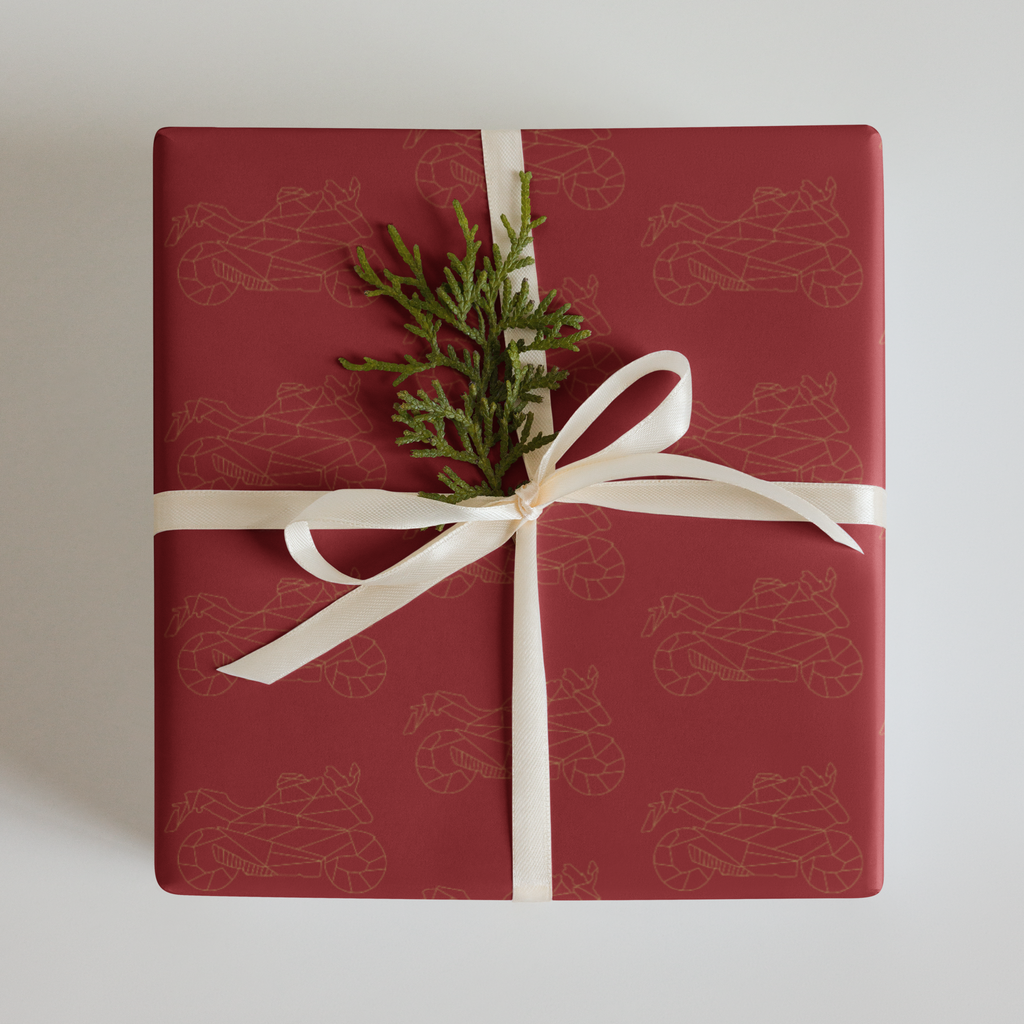 Motorcycle gift wrapping paper featuring a red background with gold motorcycle designs, topped with a festive ribbon