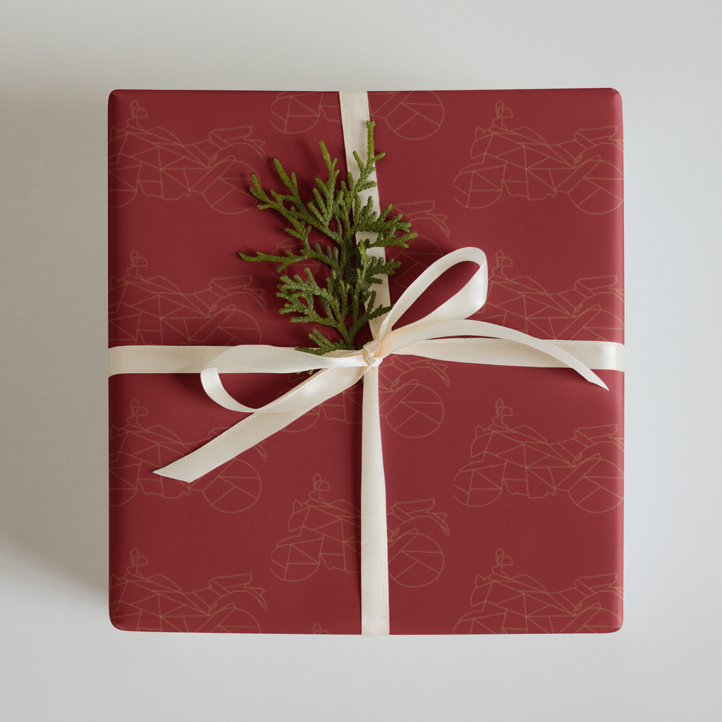 Elegant motorcycle gift wrapping paper in red with a decorative bow and greenery accent