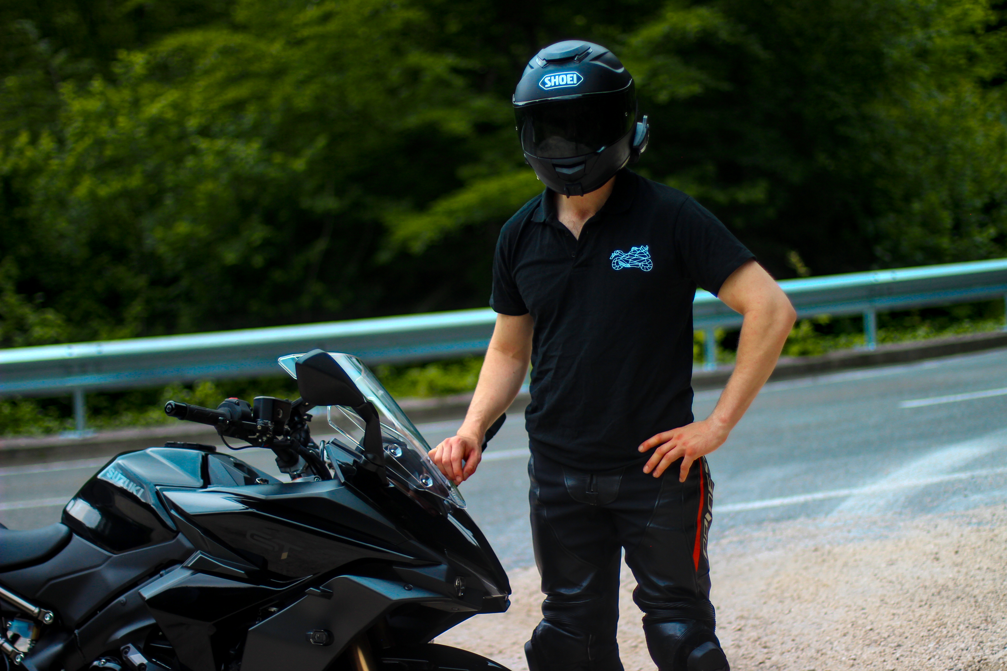 Man wearing The Biker Mule motorcycle polo shirt men standing next to black motorcycle on road