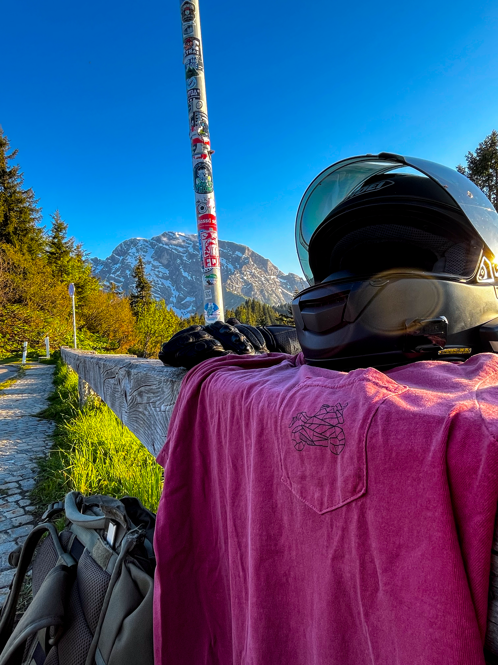 The Biker Mule motorcycle pocket shirt in red with black helmet and gloves on wooden fence outdoors